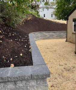a retaining wall with dirt and trees