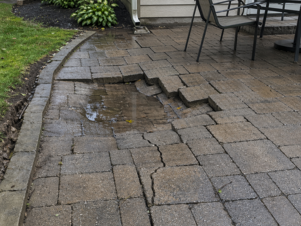 example of a paver patio that is sunken and cracked due to poor water management